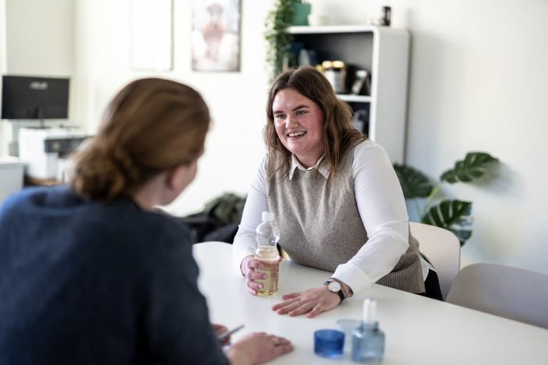 To kvinder holder møde ved et bord